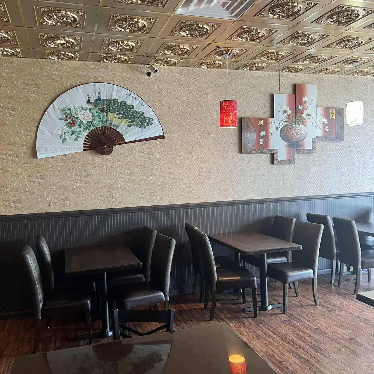 Golden-Pot-Asian-Restaurant-Wall-Decor-Jacksonville Wall with Asian - style fan and paintings as decor.